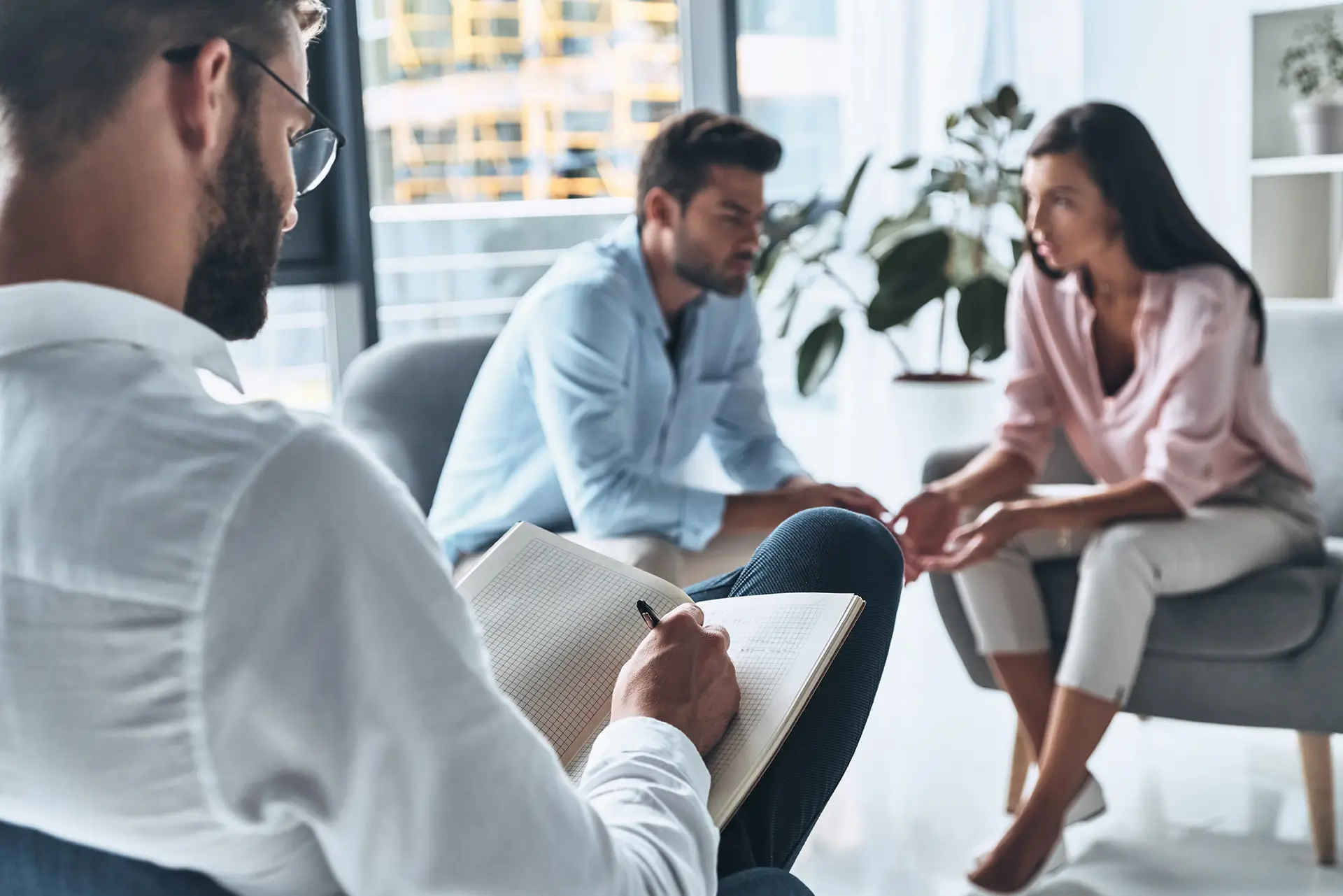 A couple talking with a certified mediator in a bright, calm office