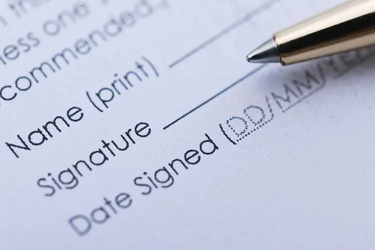 Signing a Florida divorce settlement form with a pen