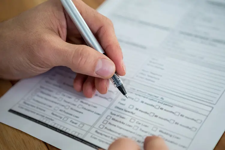 Filling out Florida divorce paperwork with a pen at a desk